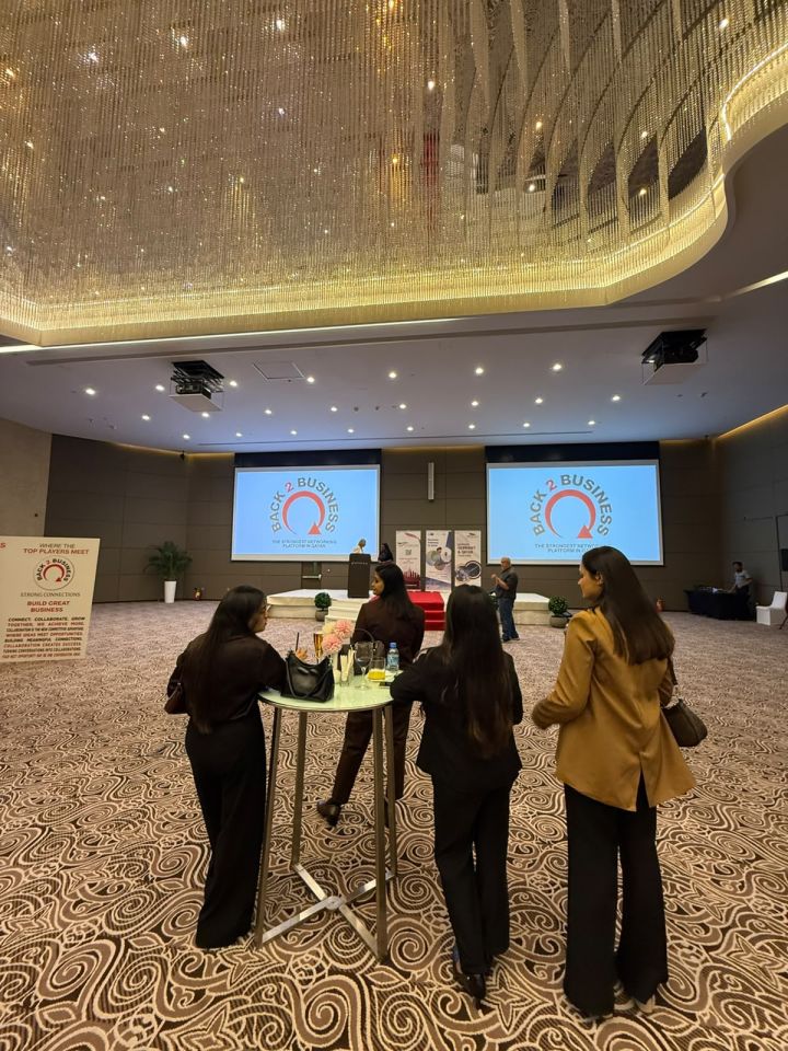 Event hall at the Back to Business networking event in Qatar with the event screens and attendees